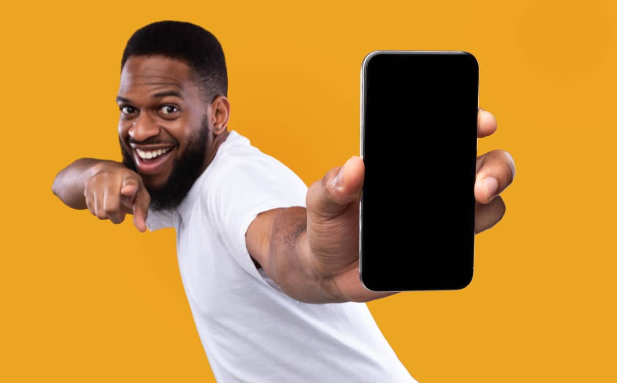 Homme sur fond jaune ravi de monter son smartphone : il a 120 Go à 10€ avec Cdiscount Mobile !