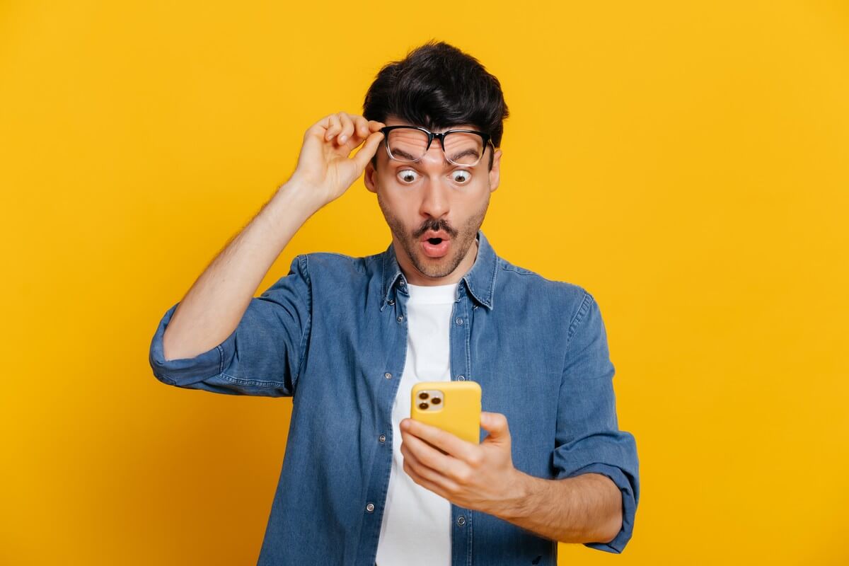 Homme bouche bée soulève ses lunettes de suprise devant le forfait mobile Free en vente privée