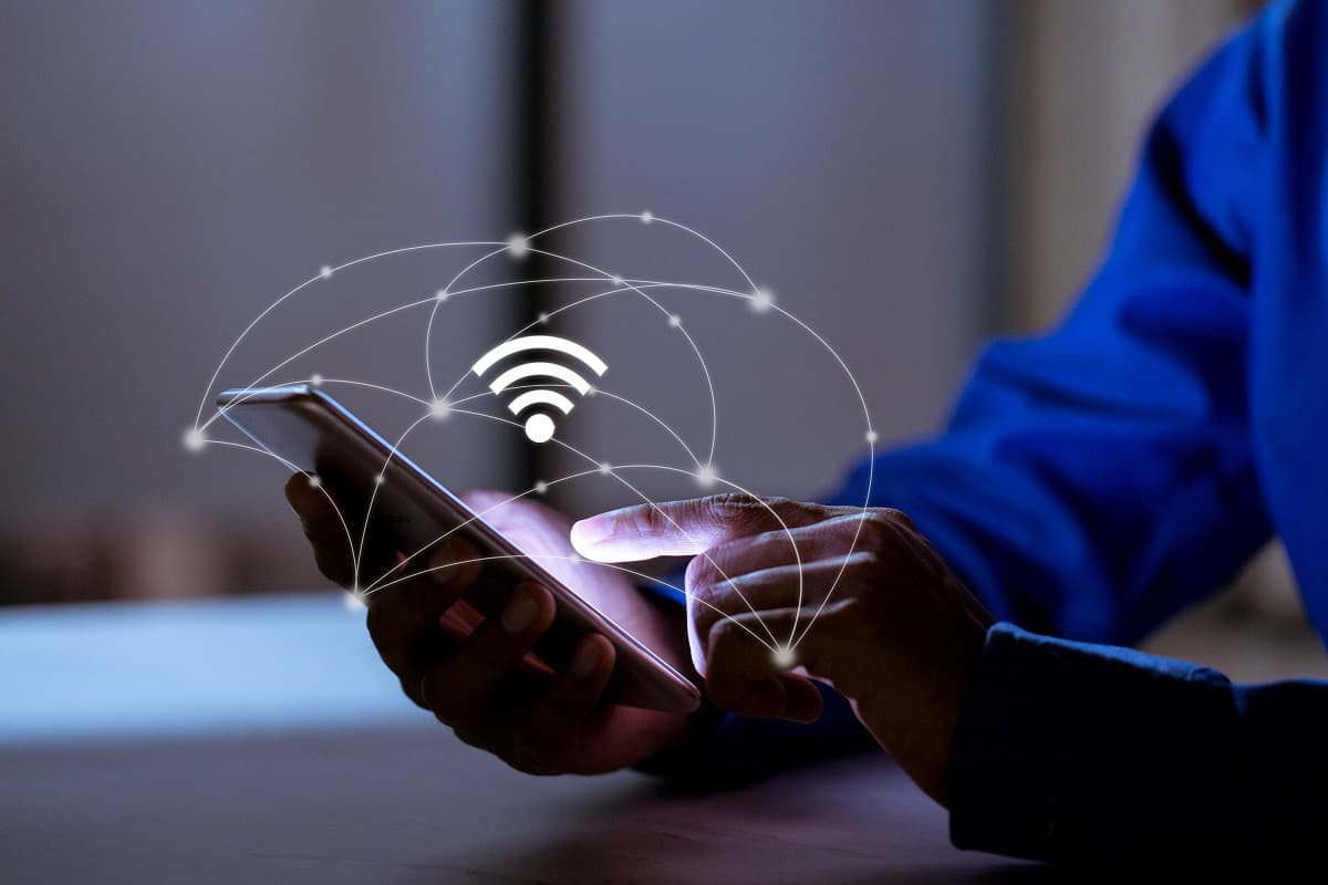 smartphone dans la main avec logo Wi-Fi, car bien connecté avec répéteurs
